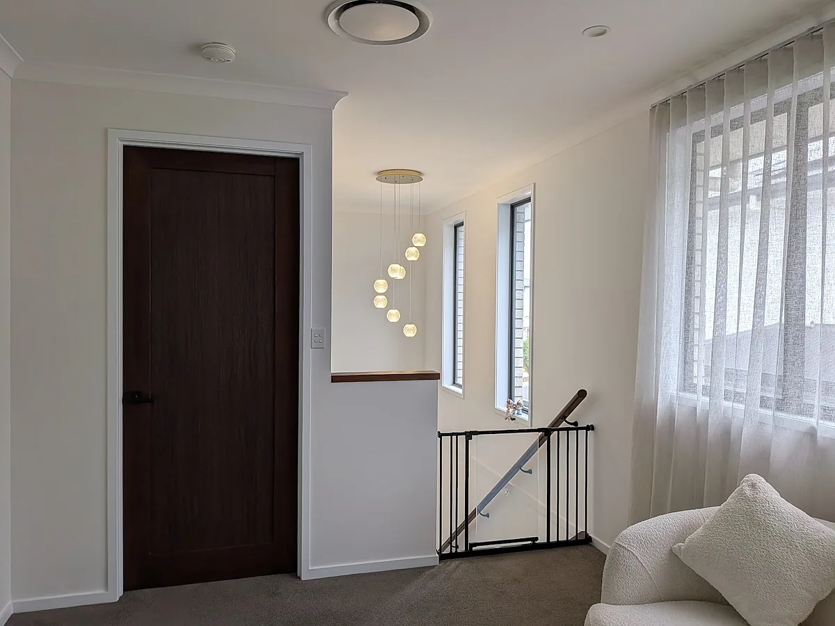 Upstairs landing with a multi-drop glass pendant lit above the stairwell
